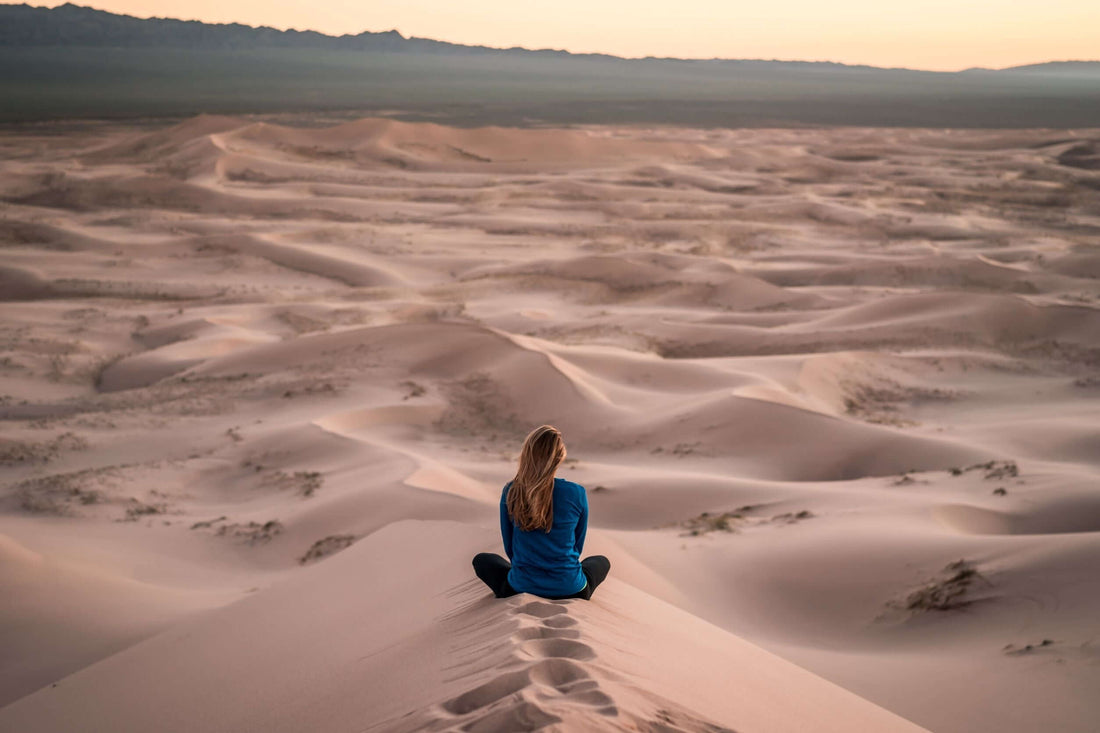 Woman meditating on sand
