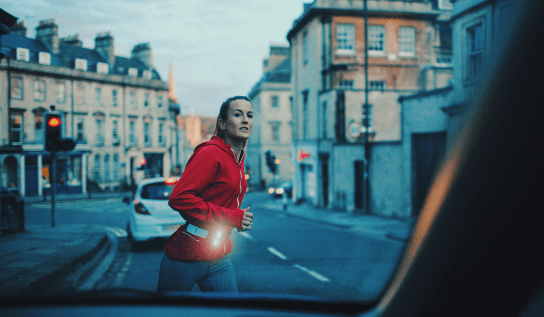 Woman running at night with the Million Mile Light battery free safety light. A motion activated running fitness light for outdoor use and no required batteries. Ideal for late night jogging and after work exercise. 