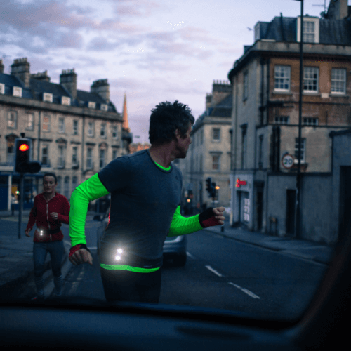 Runner jogging across road with Million Mile Light