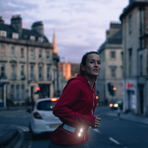 Runner jogging across road with Million Mile Light